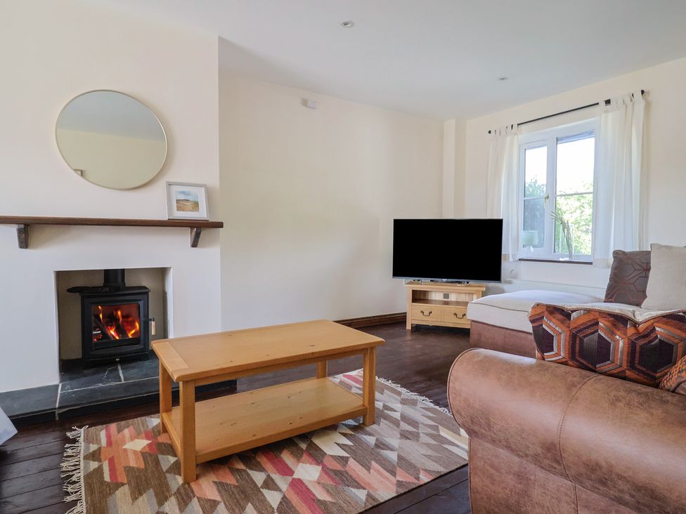 A living room with a coffee table and a fireplace at 10 The Gardens Rousdon near Lyme Regis