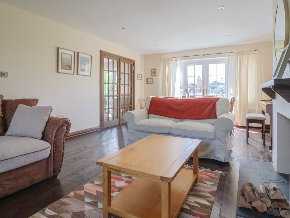 A living room with a sofa, coffee table, and fireplace at 10 The Gardens in Rousdon near Lyme Regis