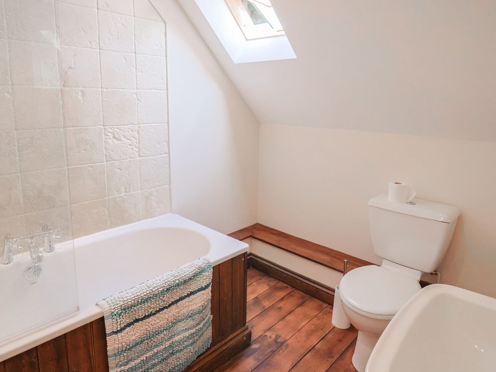 A bathroom with a bathtub and toilet at 10 The Gardens Rousdon near Lyme Regis