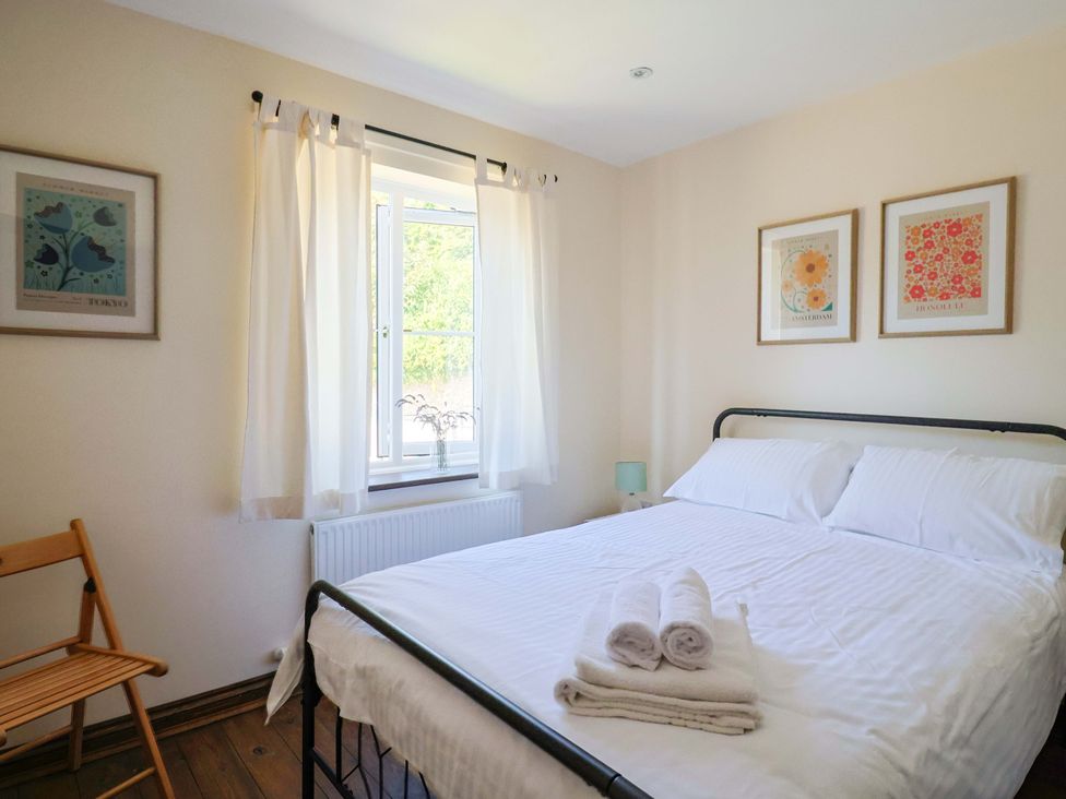 A bedroom with a bed and window at 10 The Gardens in Rousdon near Lyme Regis
