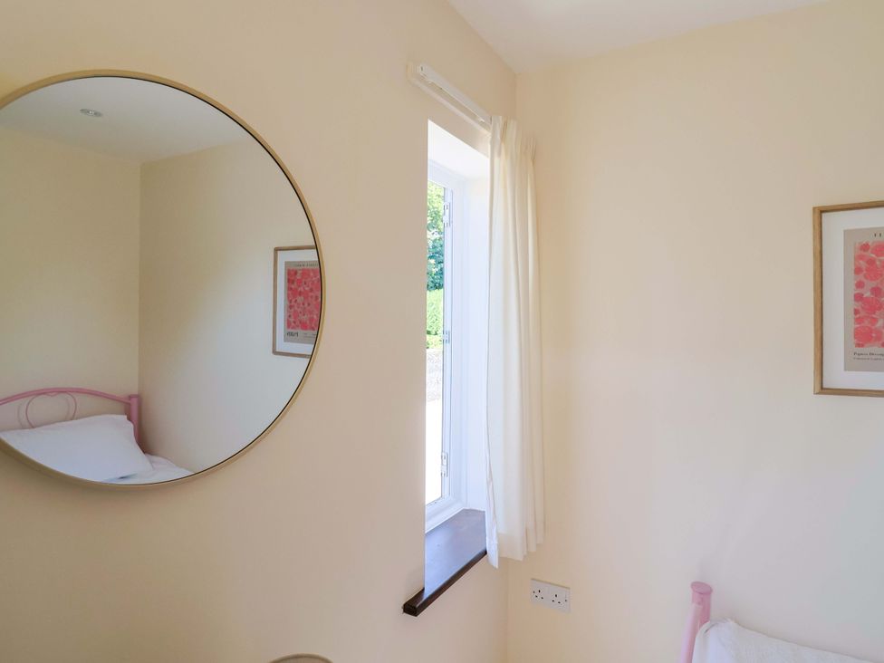 A bedroom with a bed and a window at 10 The Gardens Rousdon near Lyme Regis