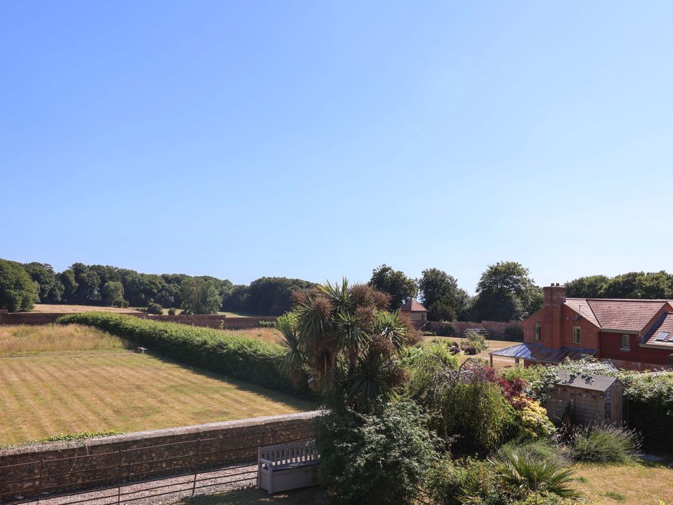 A view of a grassy field and trees at 10 The Gardens in Rousdon near Lyme Regis