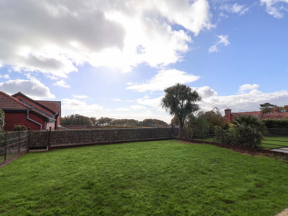 A garden with grass and trees at 10 The Gardens Rousdon near Lyme Regis