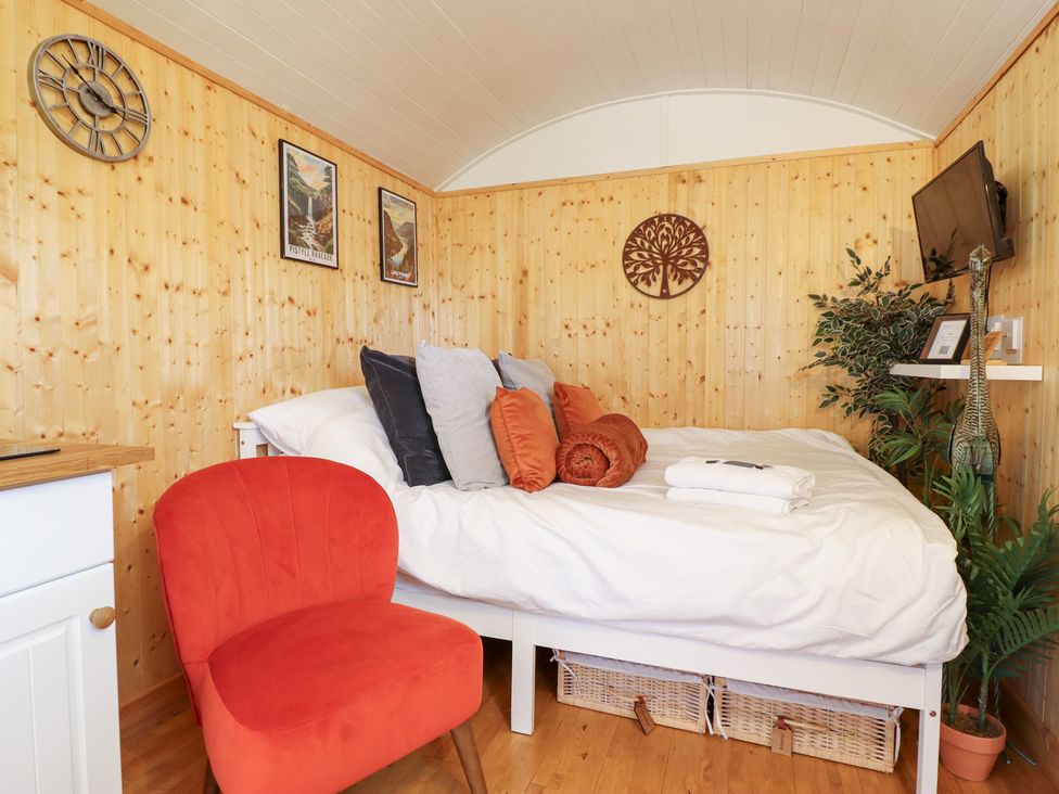 A bedroom with a bed and decor at Red Kite at Wild Valley Huts Llanrhaeadr-Ym-Mochnant