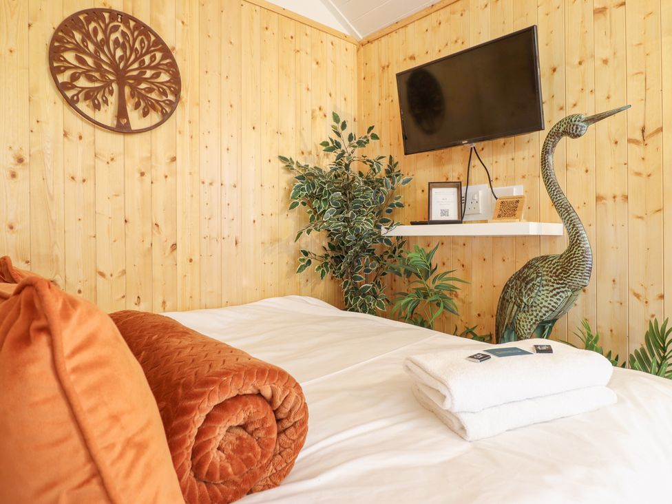 A bedroom with a bed and decorative elements at Red Kite at Wild Valley Huts Llanrhaeadr-Ym-Mochnant