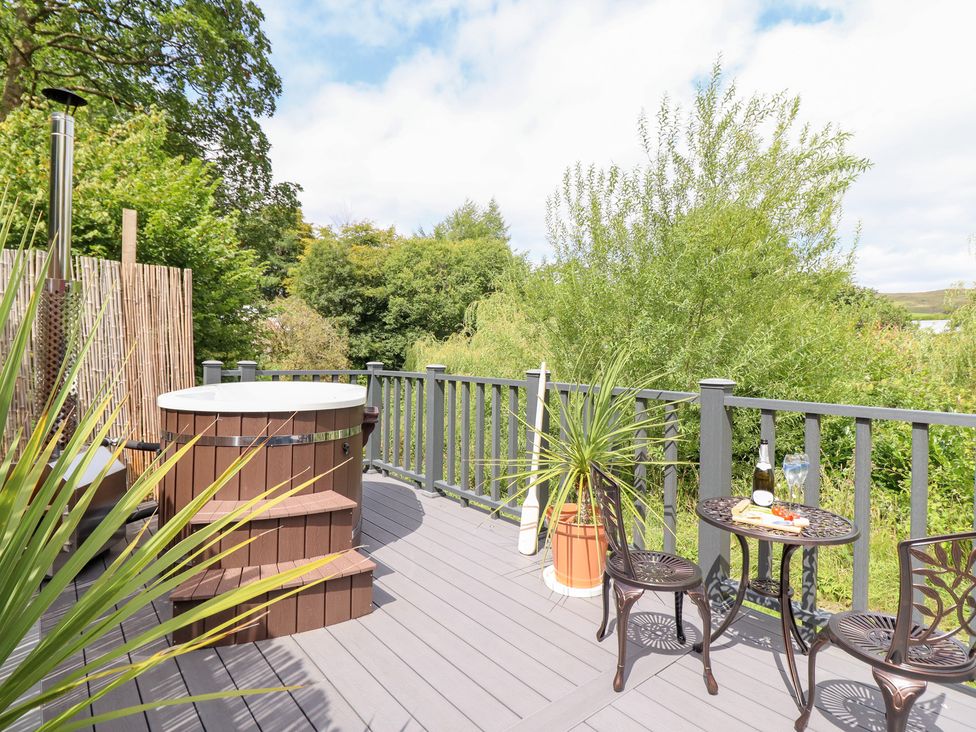 An outdoor area with a hot tub and seating at Red Kite at Wild Valley Huts in Llanrhaeadr-Ym-Mochnant