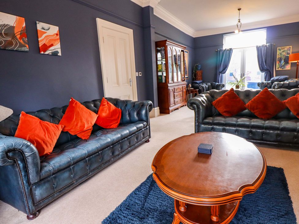 A living room with blue sofas and a wooden table at 105 Spilsby Road in Boston