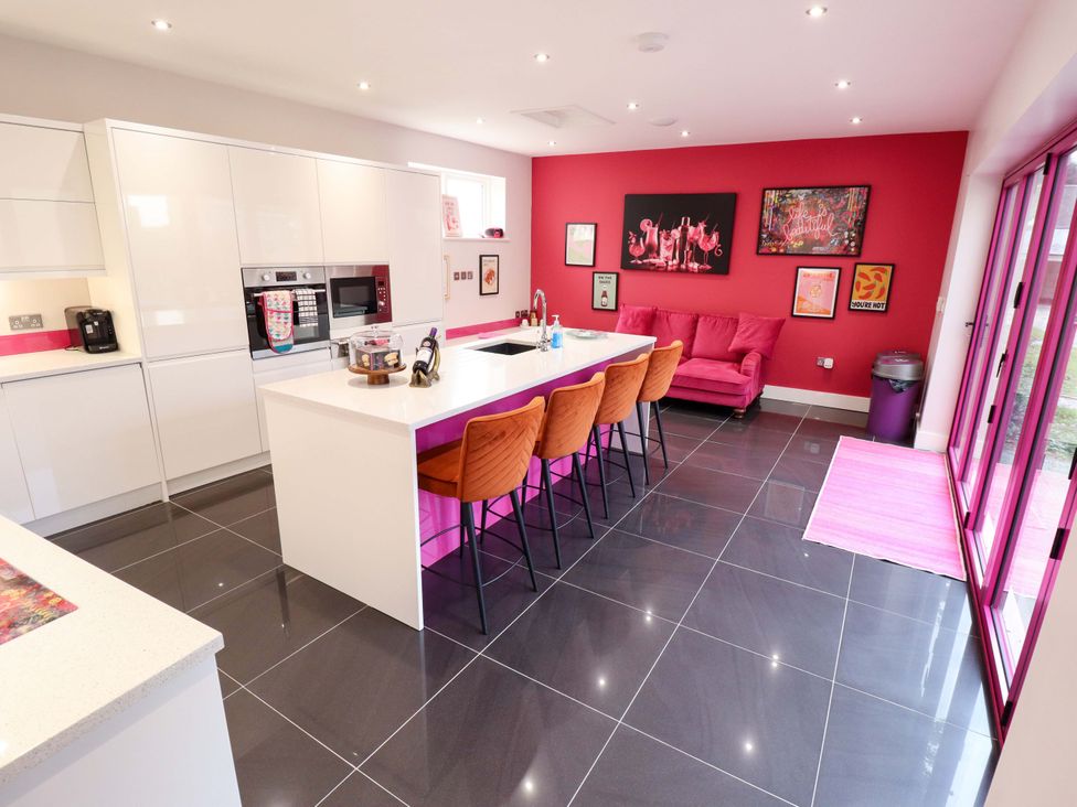 A kitchen with bar stools and a sofa at 105 Spilsby Road in Boston