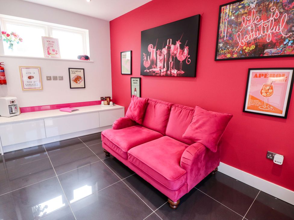 A snug with a pink sofa and artwork on the walls at 105 Spilsby Road in Boston