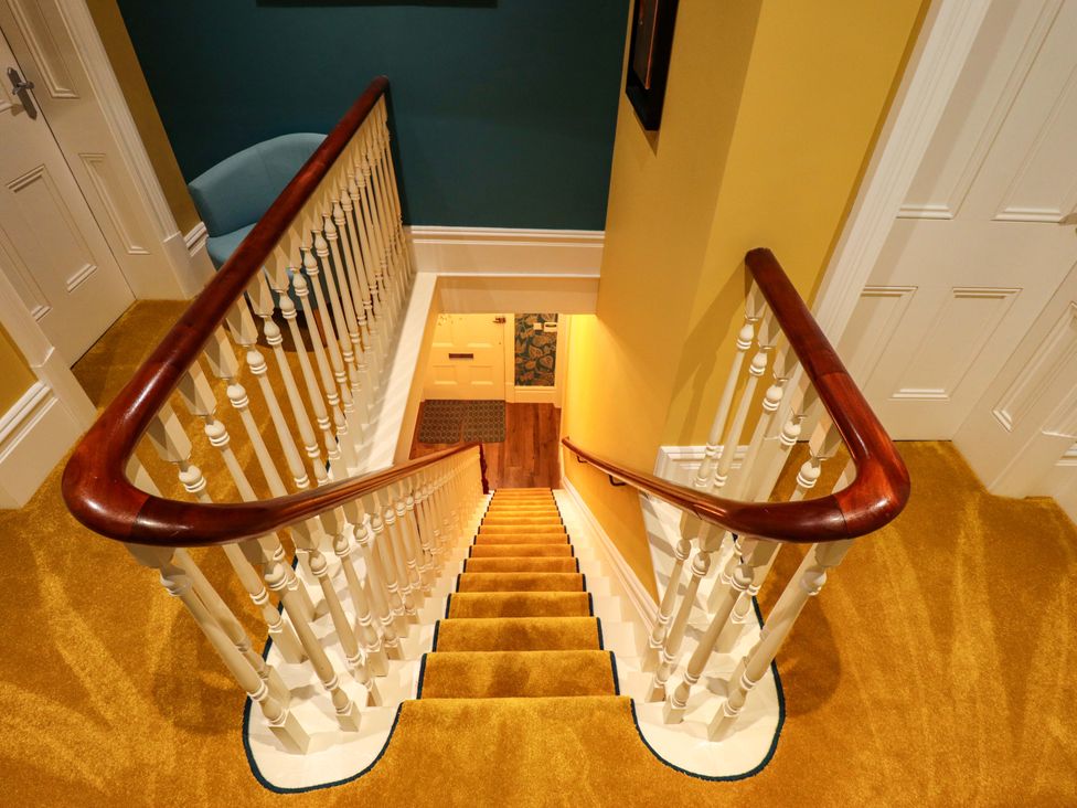 A staircase with handrail and carpet at 105 Spilsby Road in Boston