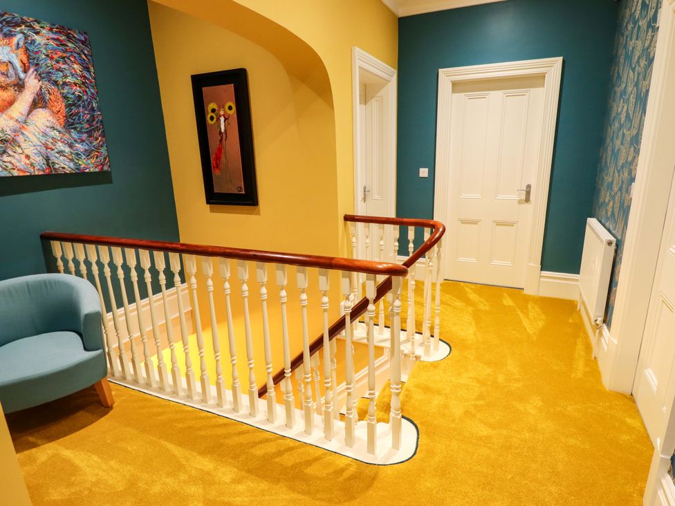 A hallway with a staircase and wall art at 105 Spilsby Road in Boston