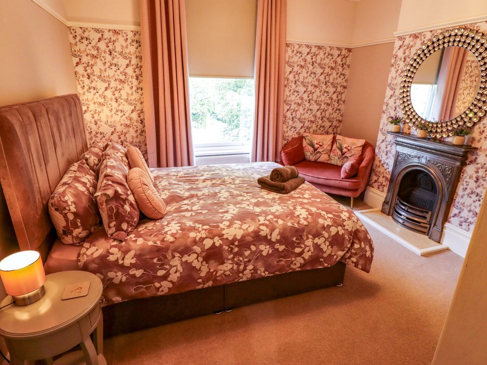 A bedroom with a large bed and armchair at 105 Spilsby Road in Boston