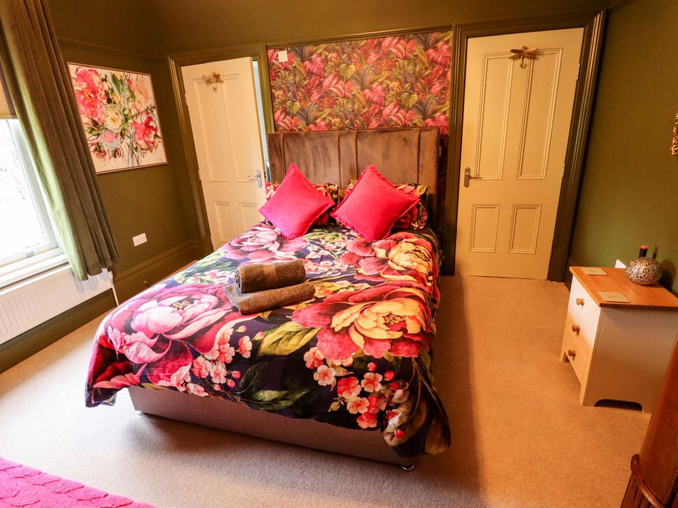 A bedroom with a bed and doors at 105 Spilsby Road Boston