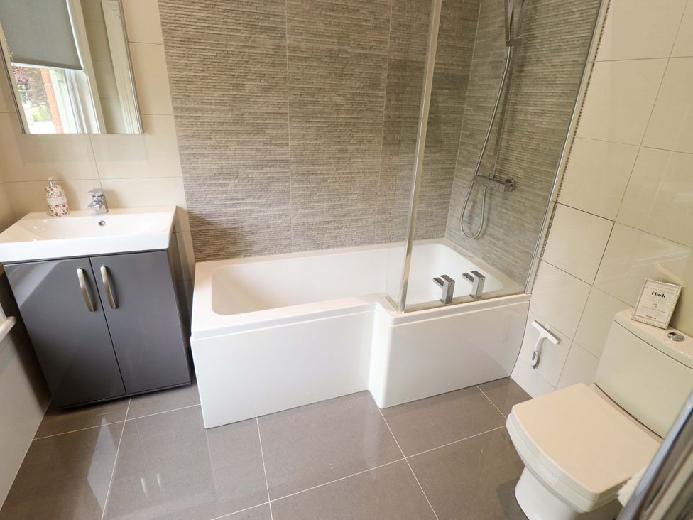A bathroom with a bathtub, shower, sink, and toilet at 105 Spilsby Road, Boston