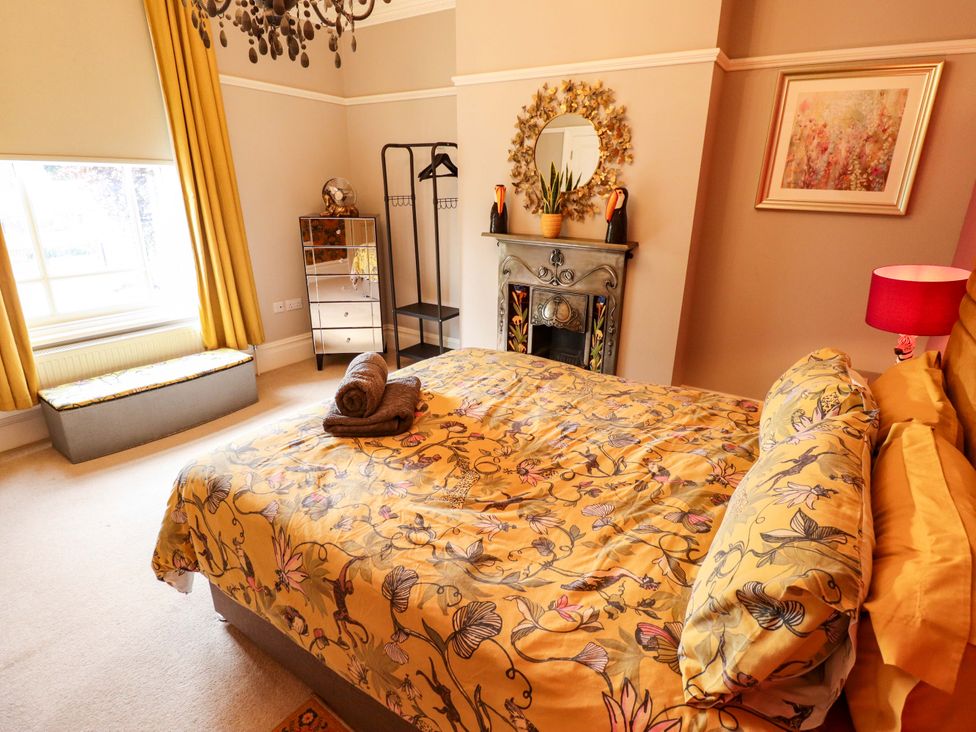 A bedroom with a bed, dressing table, and mirror at 105 Spilsby Road in Boston