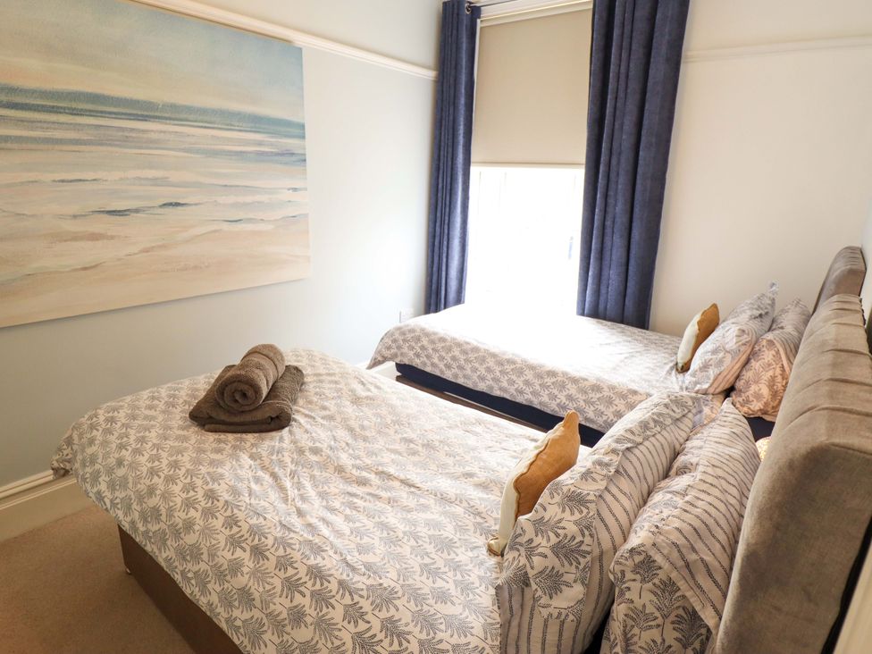 A bedroom with two beds and a painting at 105 Spilsby Road, Boston