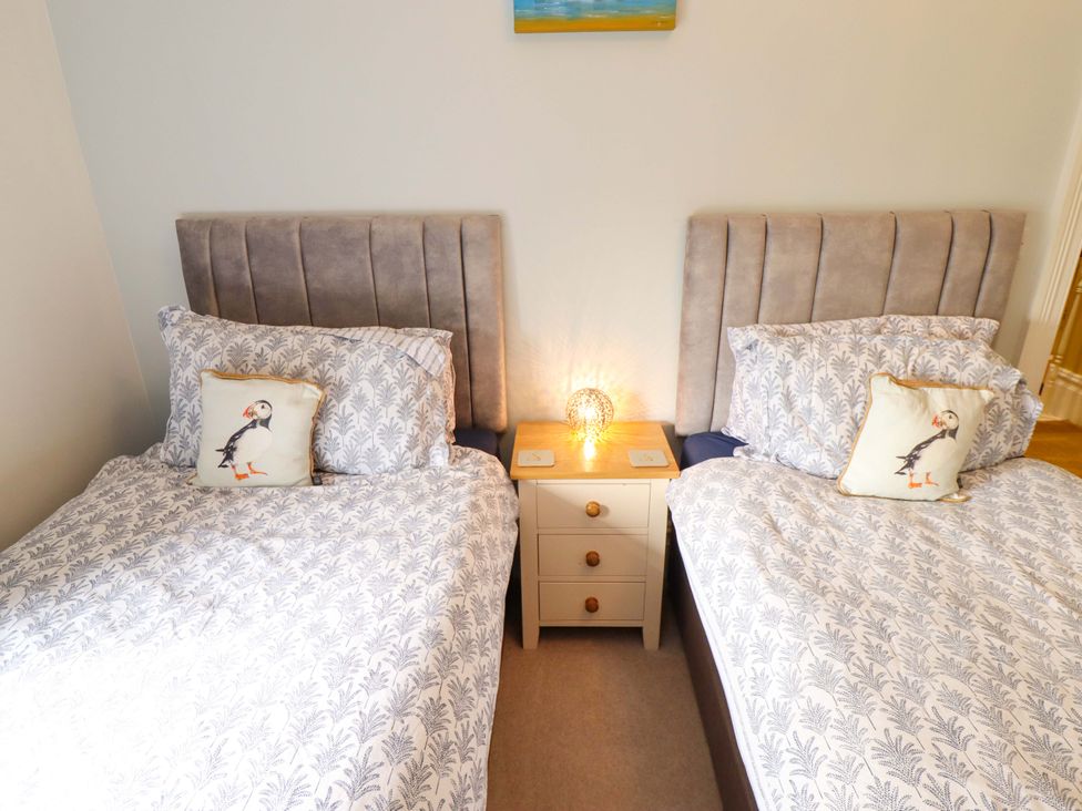 A bedroom with two beds and a bedside table at 105 Spilsby Road in Boston
