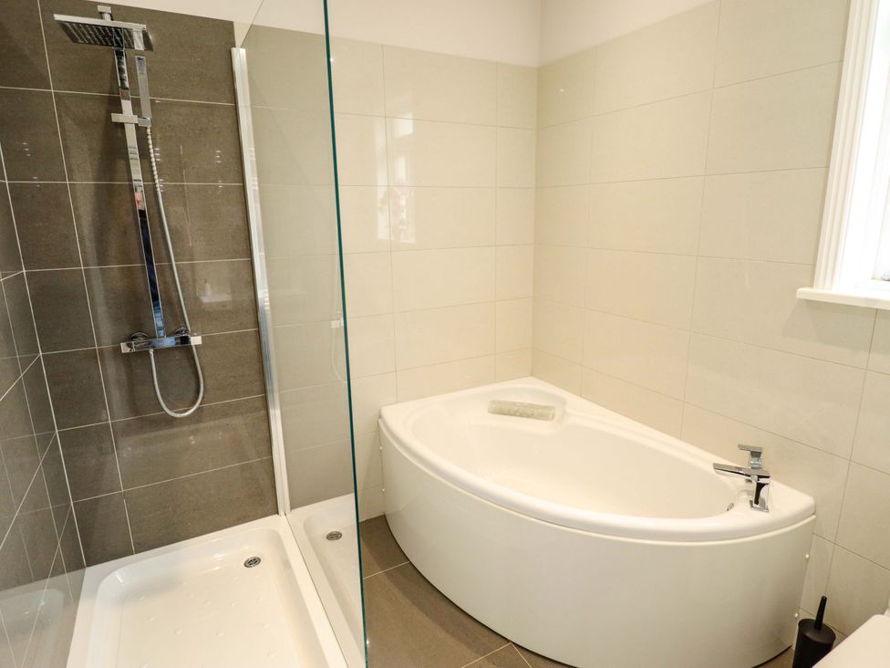A bathroom with a shower and bathtub at 105 Spilsby Road, Boston
