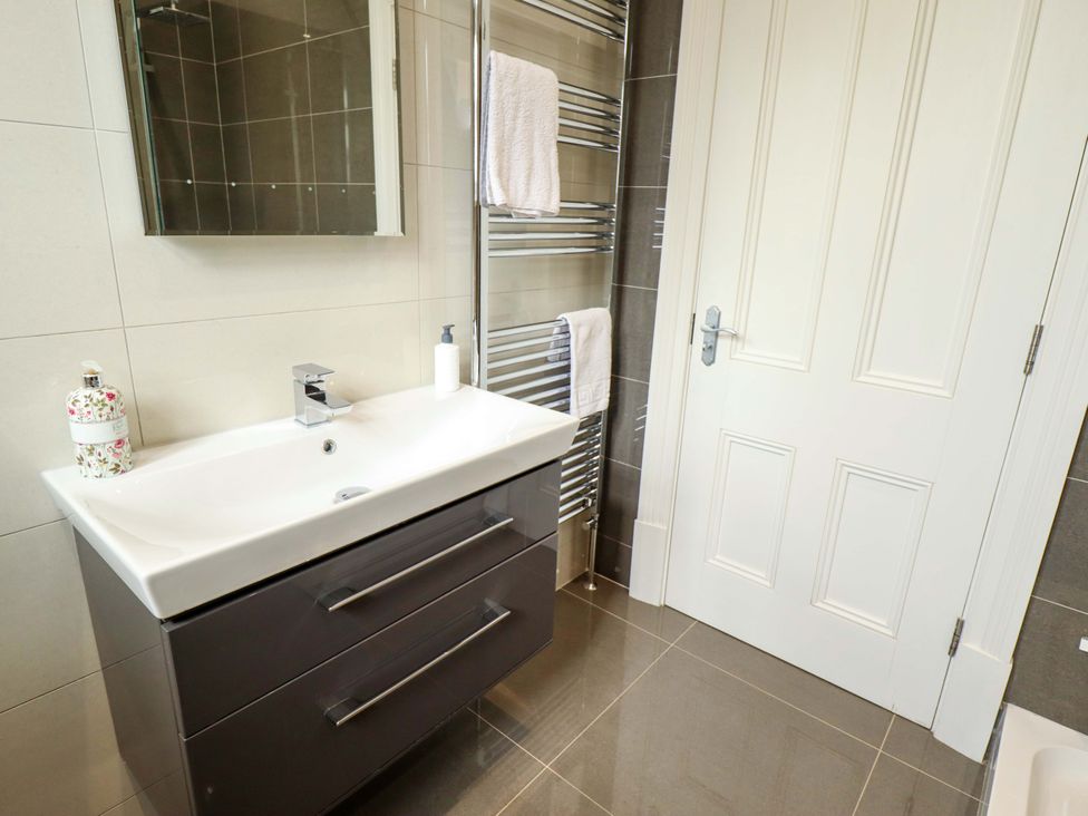 A bathroom with a vanity unit and wall mirror at 105 Spilsby Road in Boston