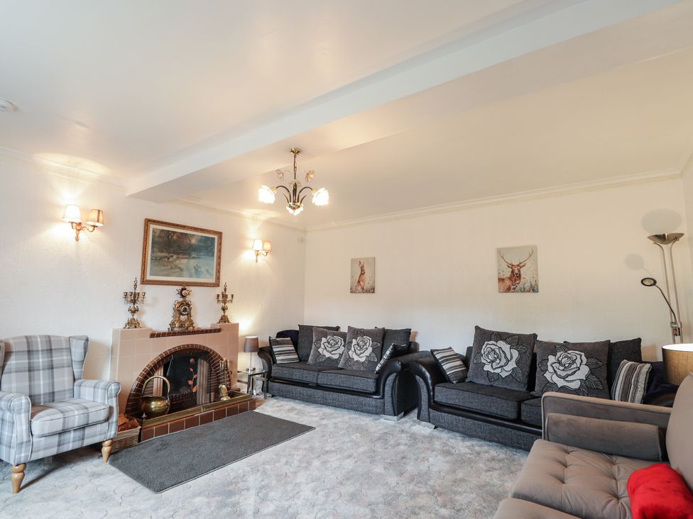 A living room with a sofa and armchair at Ivy House in Kingussie