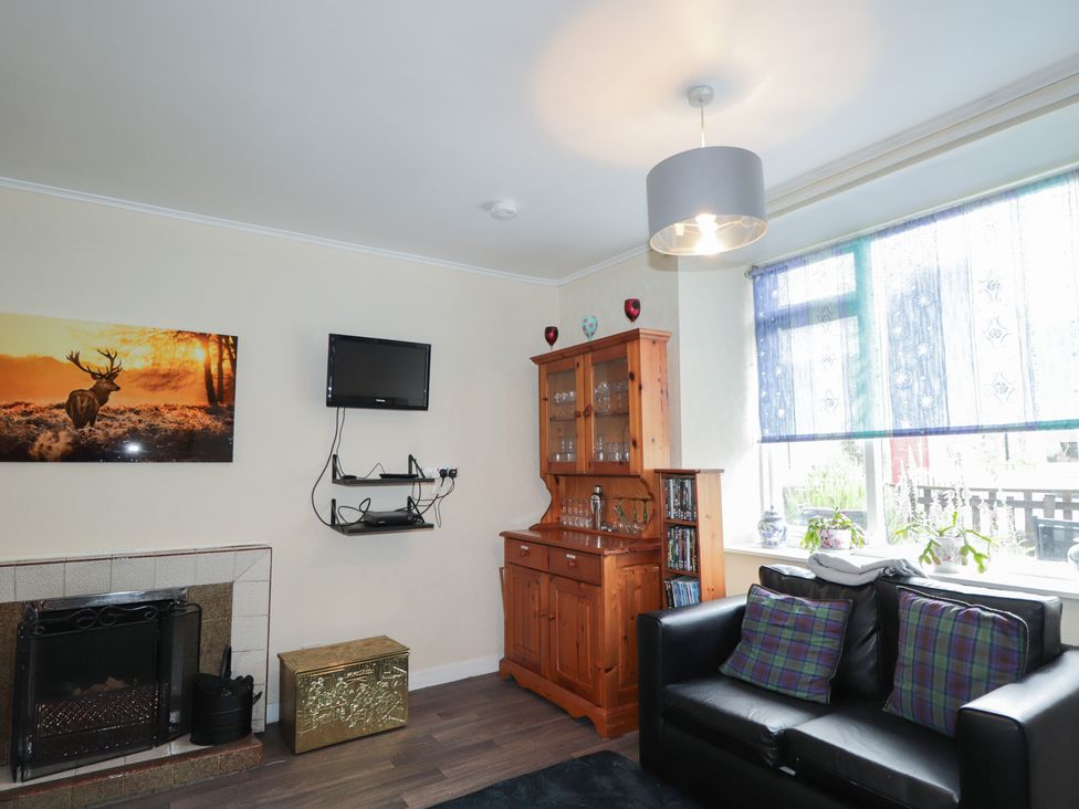 A living room with a fireplace and television at Ivy House in Kingussie