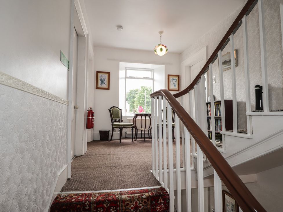 A hallway with stairs and furniture at Ivy House in Kingussie