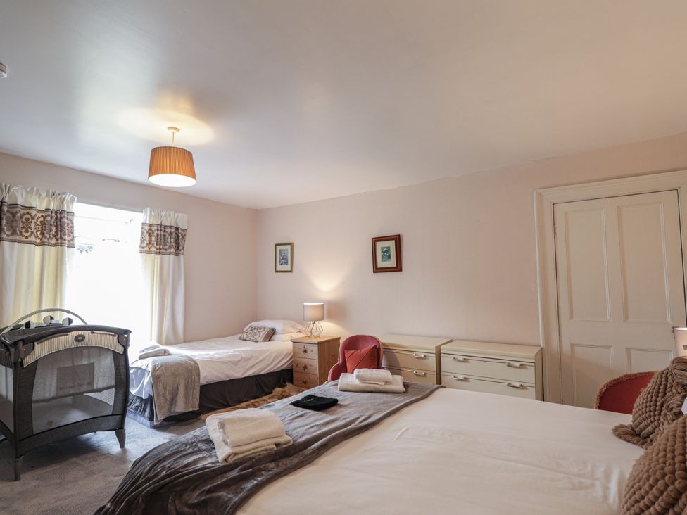 A bedroom with beds and a crib at Ivy House in Kingussie