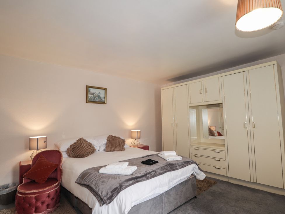 A bedroom with a bed and wardrobe at Ivy House in Kingussie