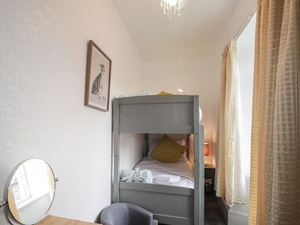 A bedroom with a bunk bed and a mirror at Ivy House in Kingussie