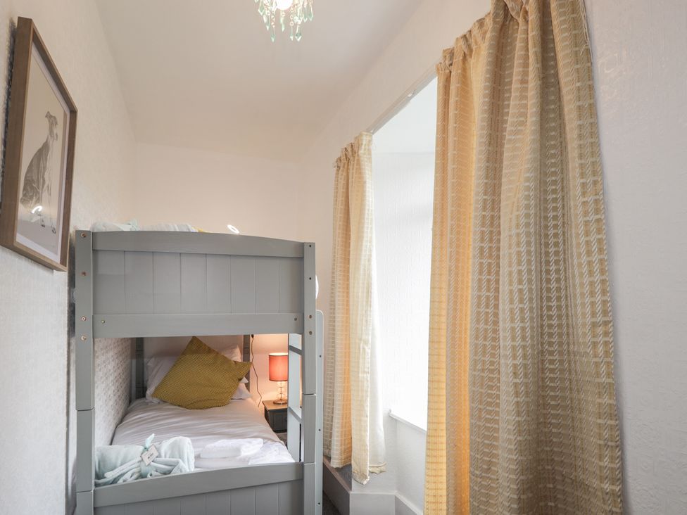 A bunk bed with a lamp and curtains at Ivy House in Kingussie