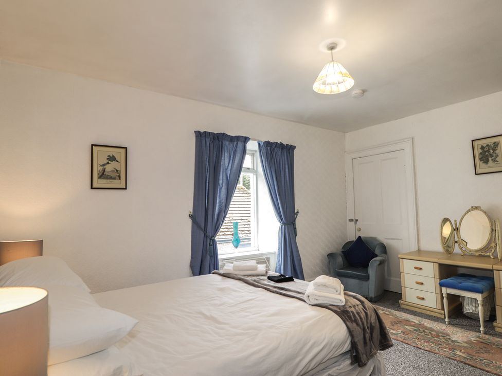 A bedroom with a bed and a vanity table at Ivy House in Kingussie