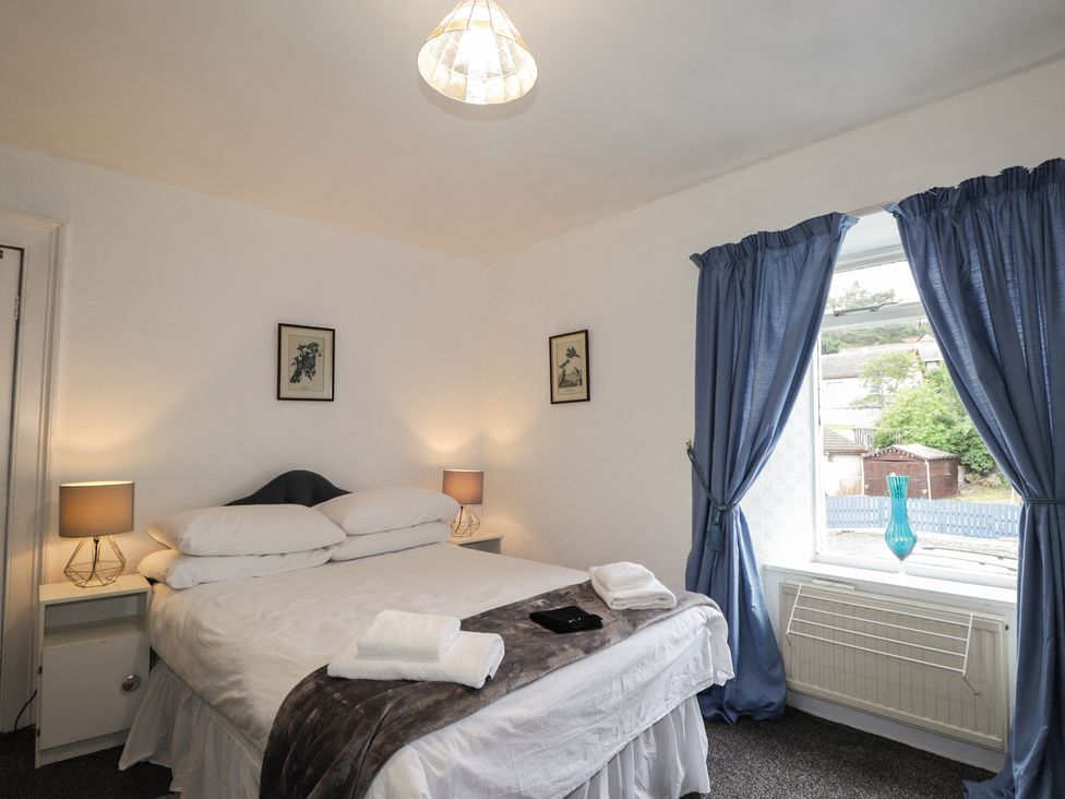 A bedroom with a bed and a window at Ivy House in Kingussie