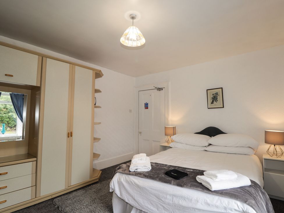 A bedroom with a bed and wardrobe at Ivy House in Kingussie