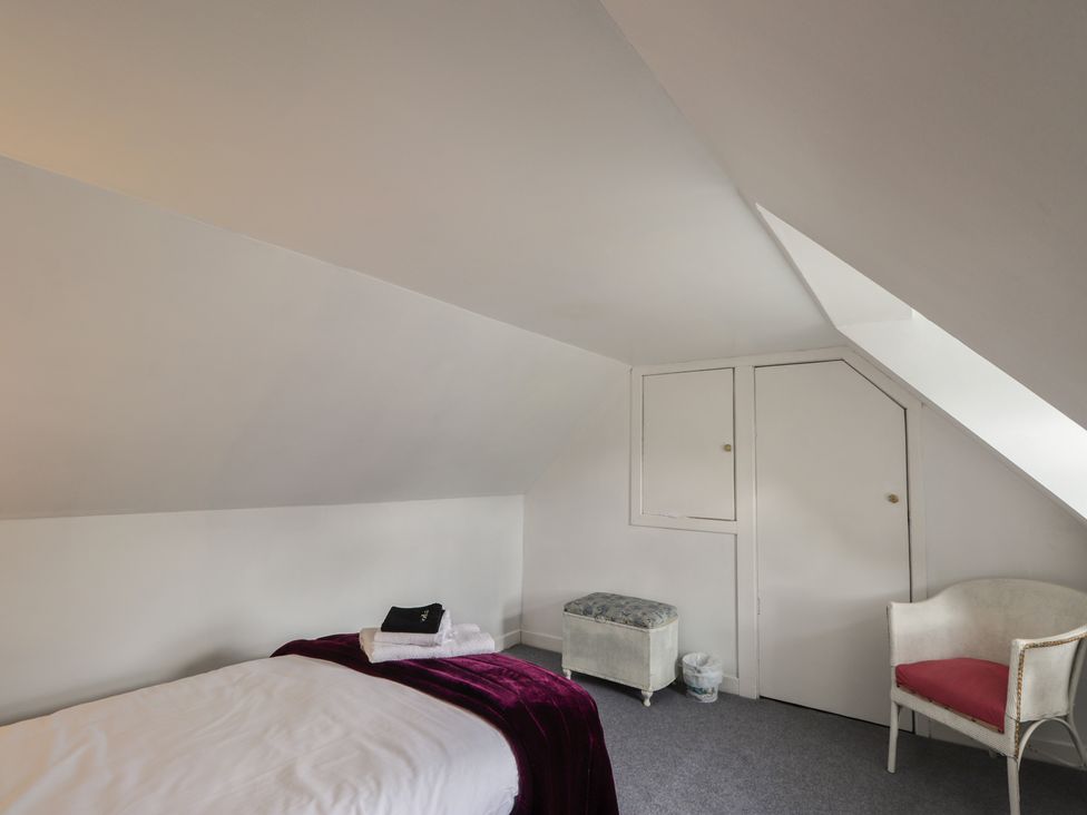 A bedroom with a bed and chair at Ivy House in Kingussie