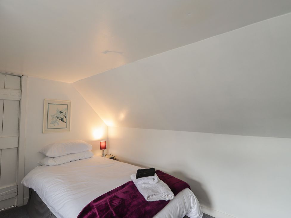 A bedroom with a bed and a lamp at Ivy House in Kingussie