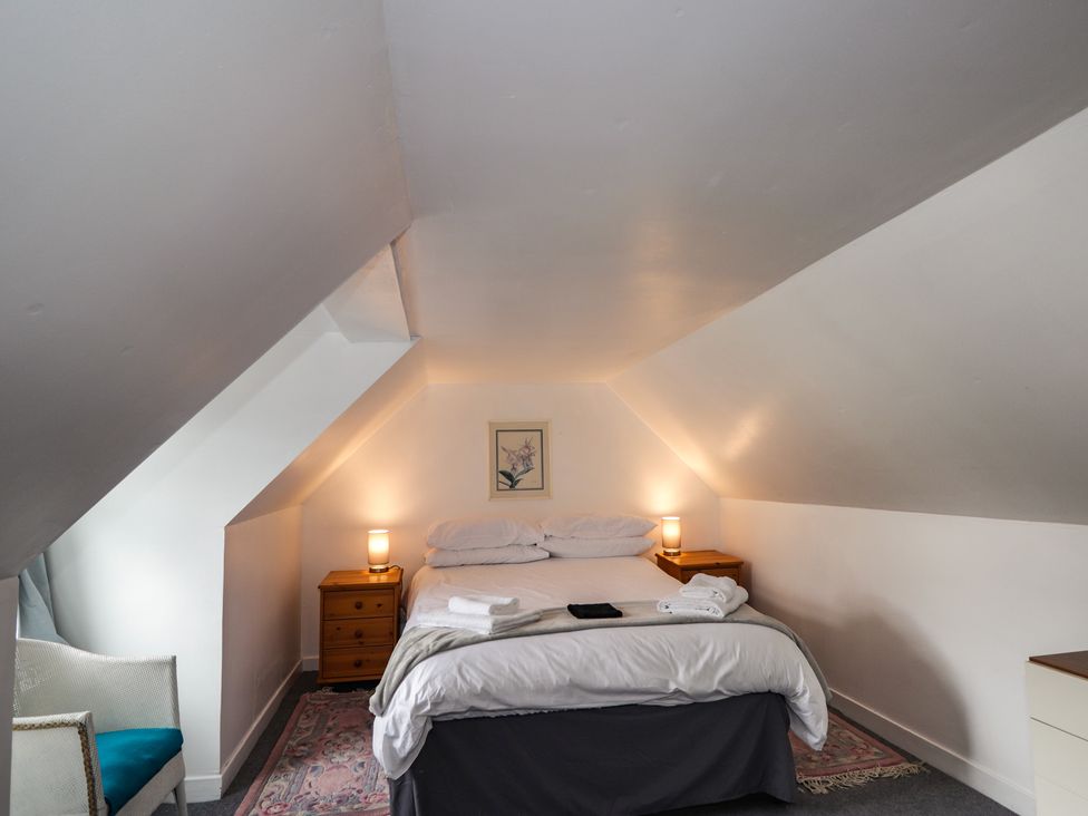 A bedroom with a bed and nightstand at Ivy House in Kingussie