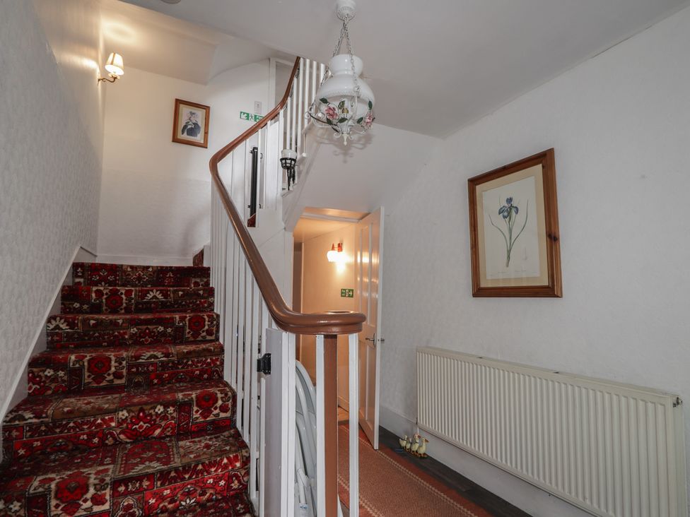 A hallway with stairs and a radiator at Ivy House in Kingussie