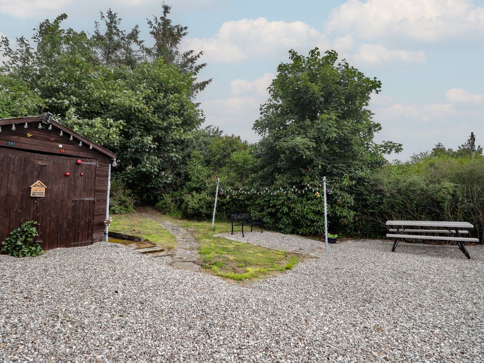 An outdoor area with a shed and a bench at Ivy House in Kingussie