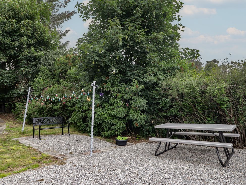A garden with a bench and table at Ivy House in Kingussie