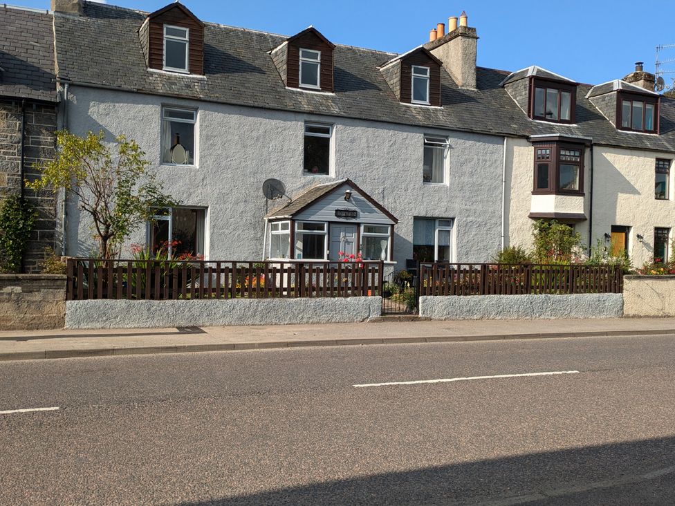 A house with a garden and fence at Ivy House in Kingussie