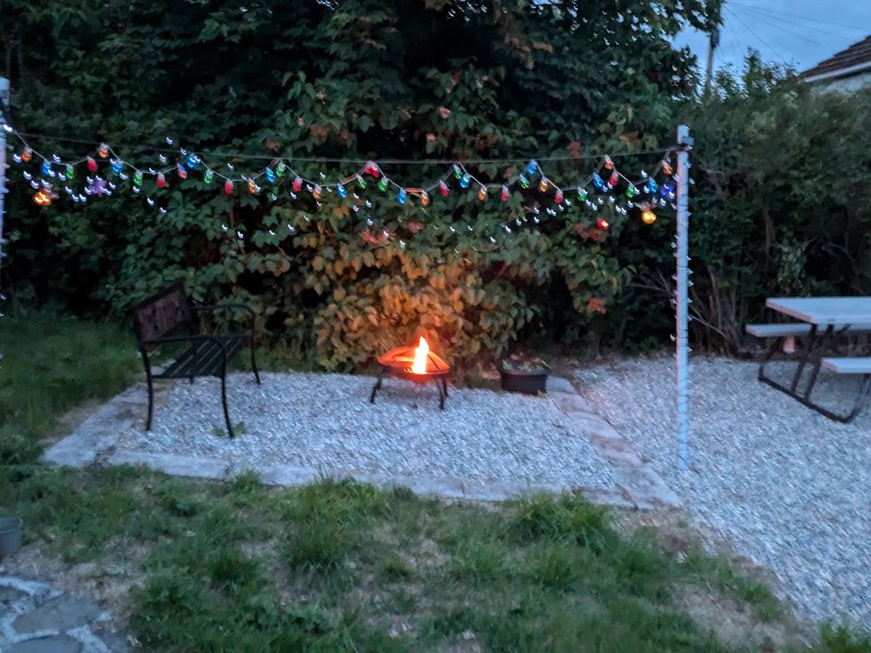 A garden with a fire pit and bench at Ivy House in Kingussie