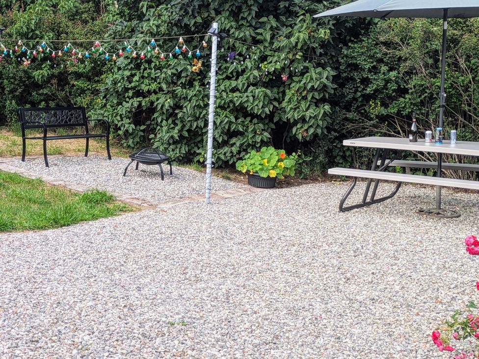 A garden with a picnic table and fire pit at Ivy House in Kingussie