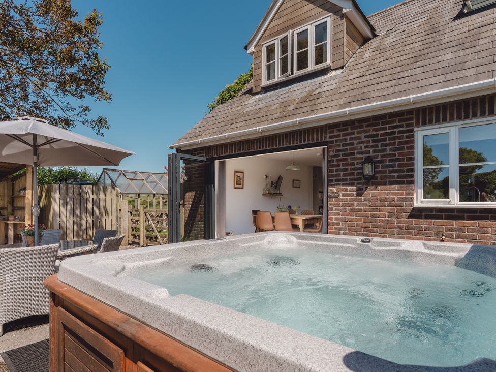 A hot tub with patio furniture at Tokenhill Cottage Piddletrenthide