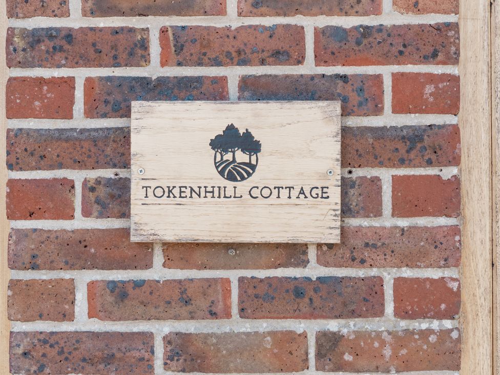 A sign labeled Tokenhill Cottage on a brick wall at Tokenhill Cottage Piddletrenthide