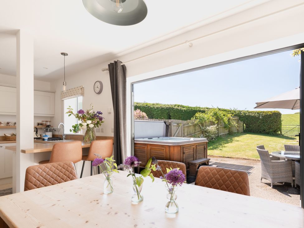 A kitchen with a dining table and flowers at Tokenhill Cottage in Piddletrenthide
