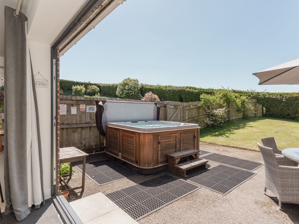 A garden with a hot tub and patio furniture at Tokenhill Cottage in Piddletrenthide
