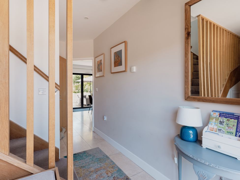 A hallway with a table and stairs at Tokenhill Cottage in Piddletrenthide