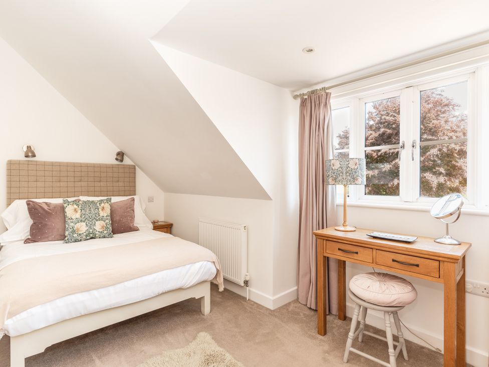 A bedroom with a bed and desk at Tokenhill Cottage in Piddletrenthide