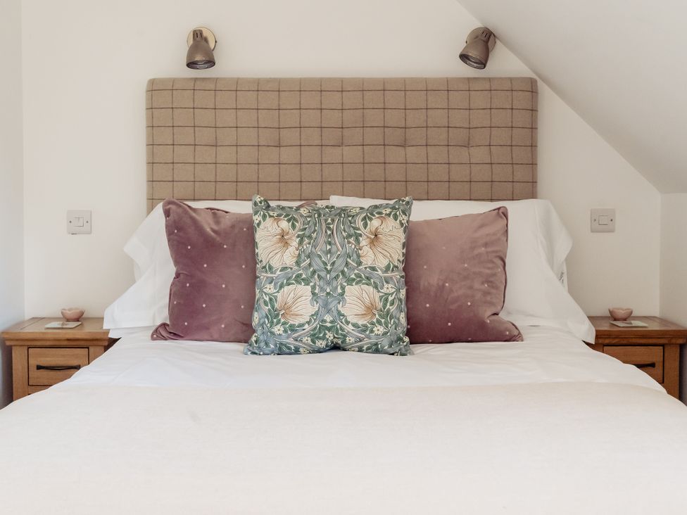 A bedroom with a bed and pillows at Tokenhill Cottage Piddletrenthide