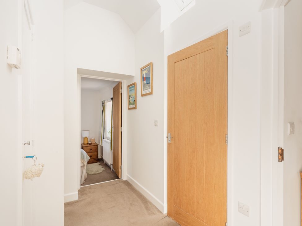 A hallway with doors and paintings at Tokenhill Cottage in Piddletrenthide